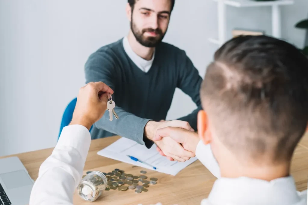 Homem recebe as chaves do novo imóvel após negociação bem-sucedida, simbolizando a conclusão de um contrato de consórcio ou financiamento imobiliário.