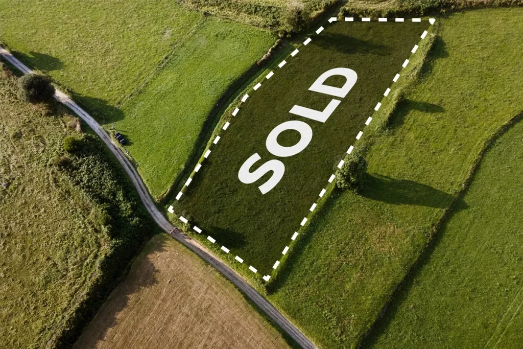 Vista aérea de terreno marcado com a palavra "SOLD" em letras grandes no centro, com cercado de linha pontilhada, localizado em uma área rural.