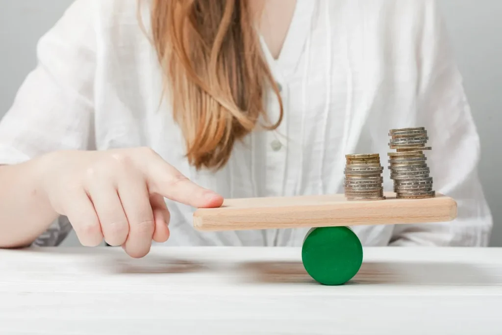 Pessoa ajustando uma balança com moedas, simbolizando equilíbrio financeiro e estratégias de investimentos