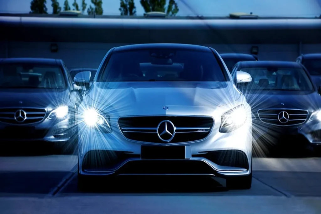 Carros de luxo com faróis acesos em destaque, representando conquista por meio da carta de crédito contemplada