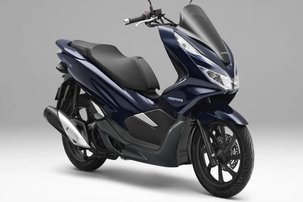 Scooter Honda PCX híbrida azul escura vista de perfil em fundo cinza claro, destacando seu design moderno