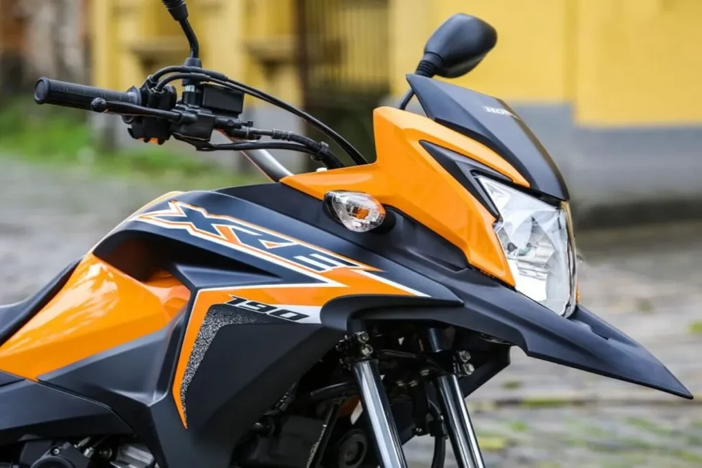 Close-up da Honda XRE 190 na cor amarela, destacando o farol, carenagem e guidão, perfeita para quem deseja entrar em um consórcio de moto
