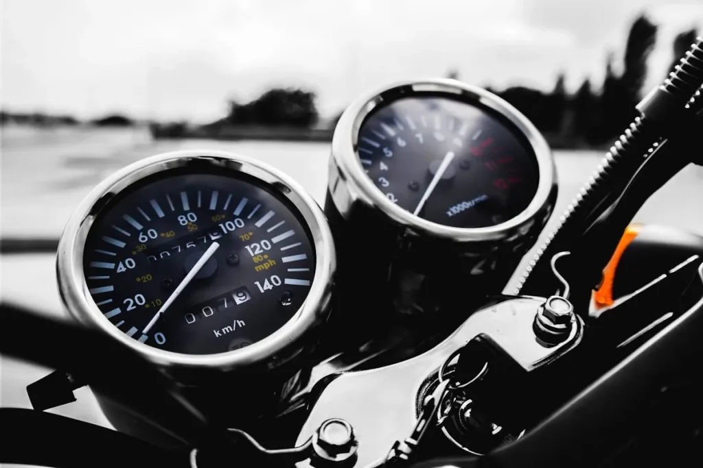 Um painel de instrumentos de uma mota com velocímetro e conta-rotações. A imagem simboliza a contemplação num consórcio de motos e a emoção da sua utilização.