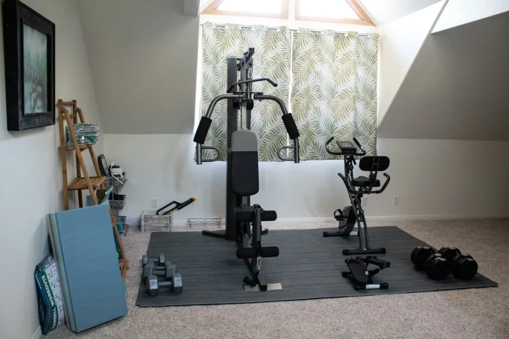 Academia em casa equipada com estação de musculação, bicicleta ergométrica, halteres e colchonetes