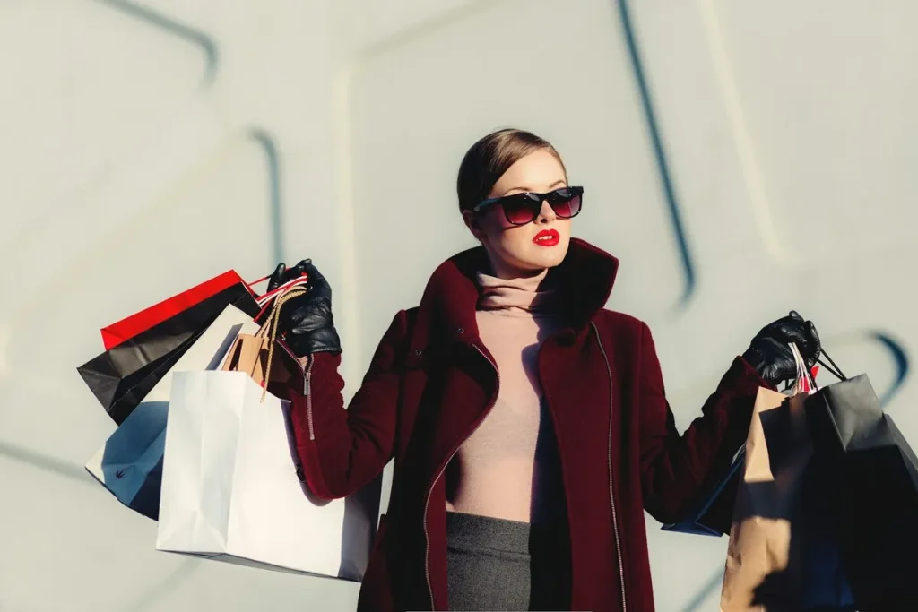 Mulher elegante com sacolas de compras simbolizando alto poder aquisitivo