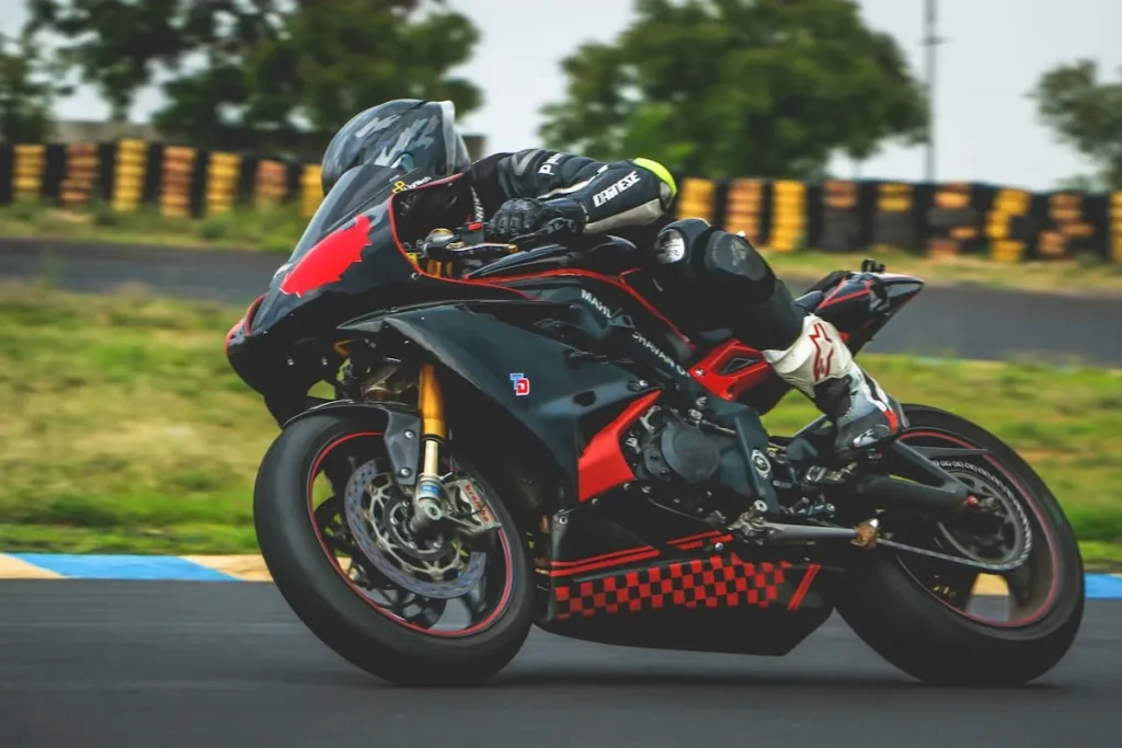 Piloto de corrida de moto em uma pista, realizando uma curva acentuada, representando a precisão e a habilidade necessárias em eventos de alta performance como uma assembleia.