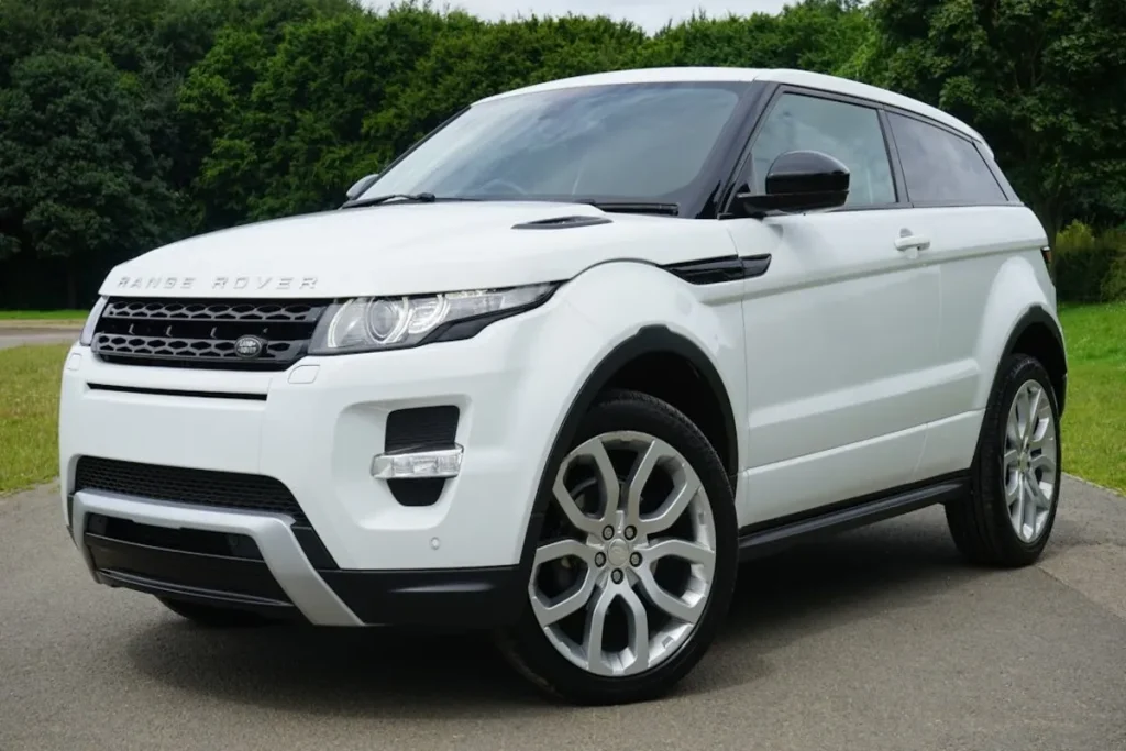 Um carro branco de luxo, um Range Rover Evoque, parado em uma estrada, simbolizando a modernidade e a qualidade que podem ser discutidas em uma assembleia.
