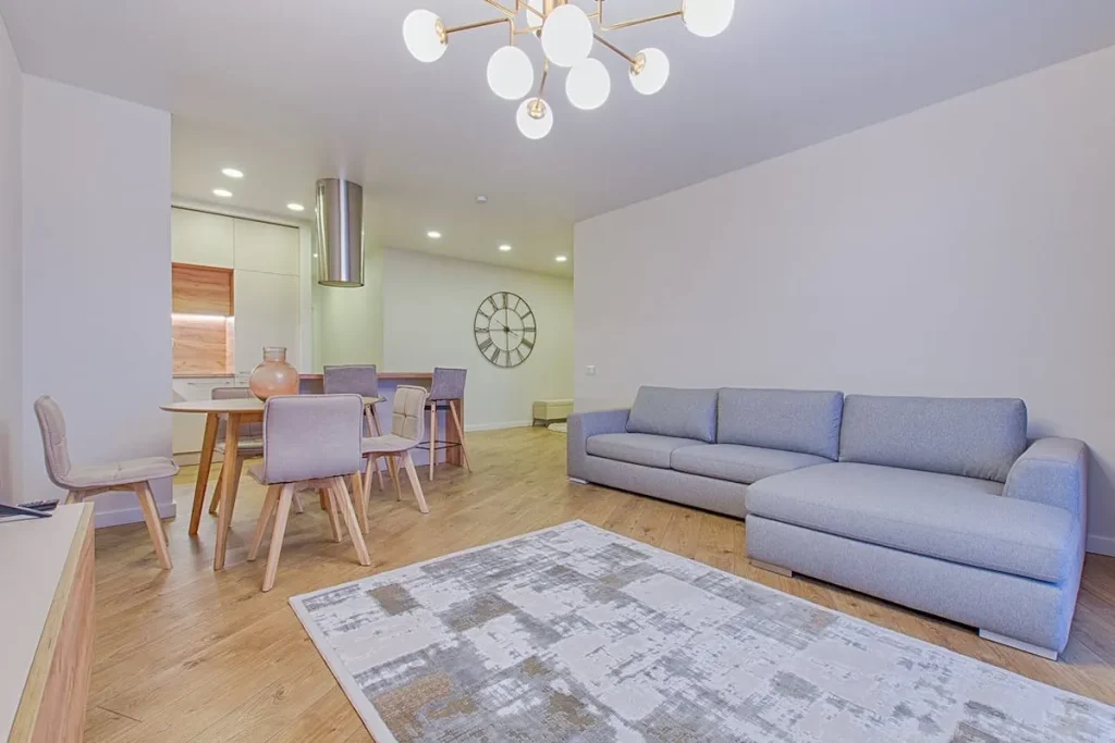 Uma sala de estar de um apartamento de luxo, com grandes janelas, sofás modernos e iluminação natural. A imagem destaca a importância de um projeto de casa planejada.