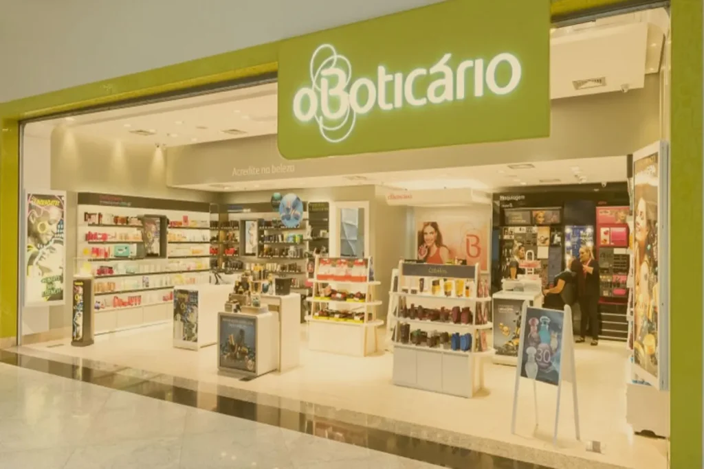 Fachada de uma loja de franquia O Boticário em um shopping center, com produtos de beleza e cosméticos em exposição.