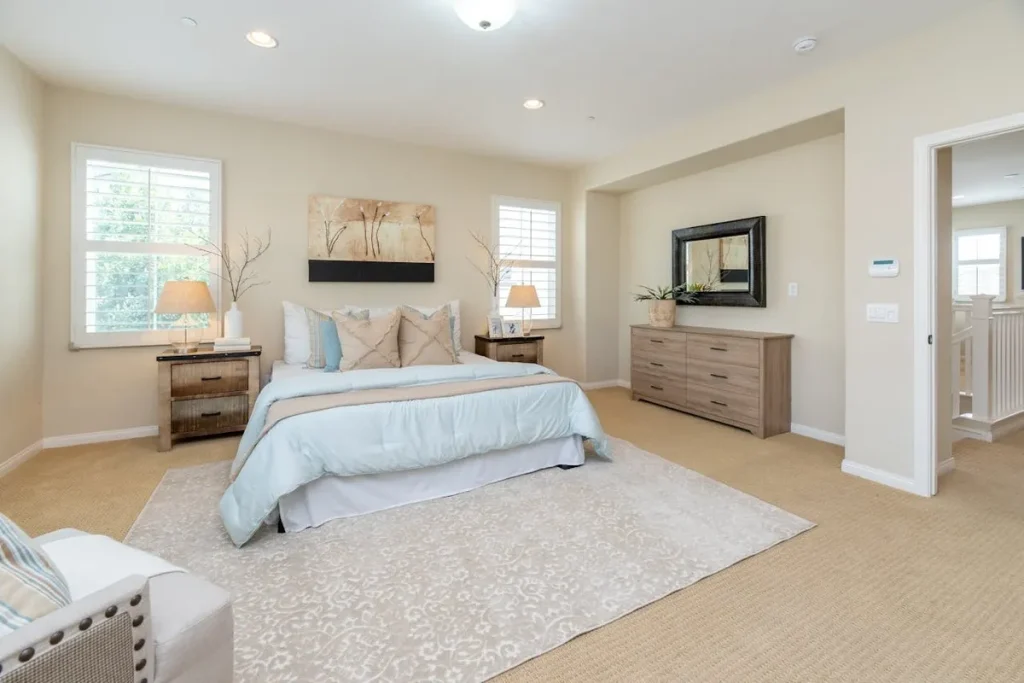 Quarto de casal com cama, cômoda e abajures. A imagem mostra o interior de um imóvel, ideal para locação de imóvel.