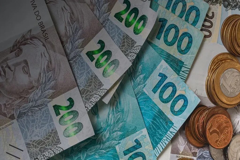 Notas de dinheiro de R$ 200, R$ 100 e moedas de R$ 1,00, empréstimo pessoal, o que é empréstimo, dinheiro, finanças