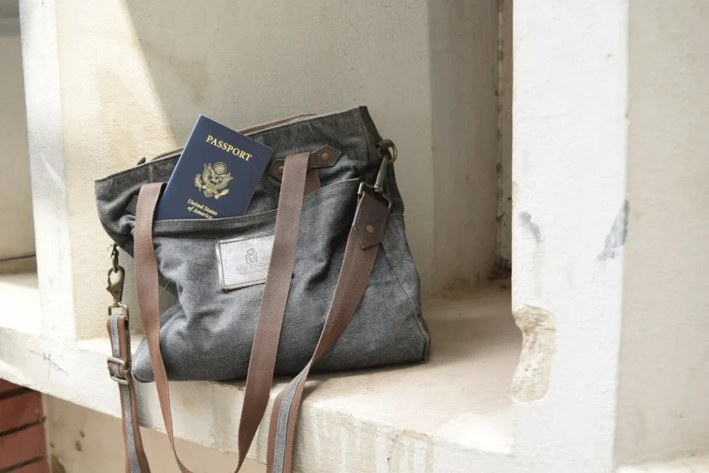 Um passaporte dos Estados Unidos dentro de uma bolsa de viagem de tecido cinza, pronta para uma viagem internacional.