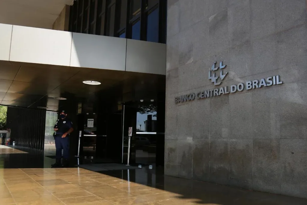 Fachada do edifício do Banco Central do Brasil com segurança, simbolizando a sua solidez institucional.