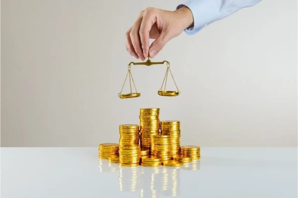 Uma mão de terno segurando uma balança de dois pratos (símbolo de equilíbrio e justiça) sobre pilhas de moedas douradas. A cena, com a balança pairando sobre o dinheiro, simboliza a tributação e o controle financeiro, representando o IOF (Imposto sobre Operações Financeiras) e seu papel na regulação do mercado e da economia.