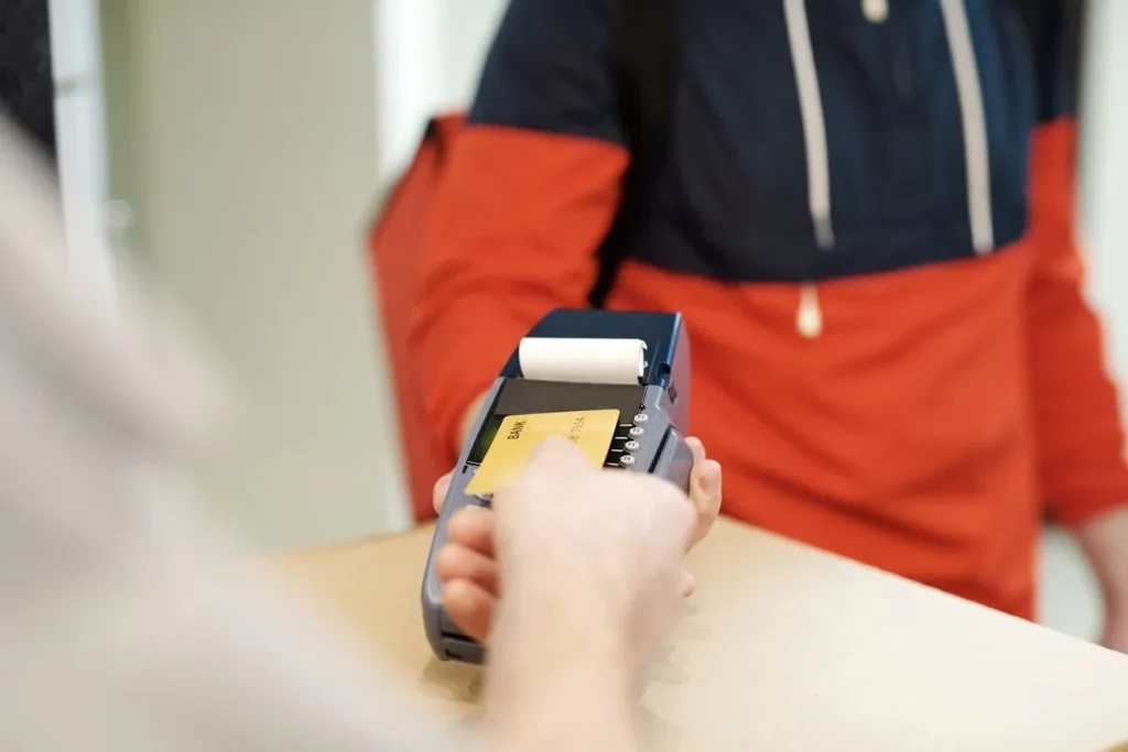 Uma pessoa realiza um pagamento por aproximação usando um cartão de crédito internacional.