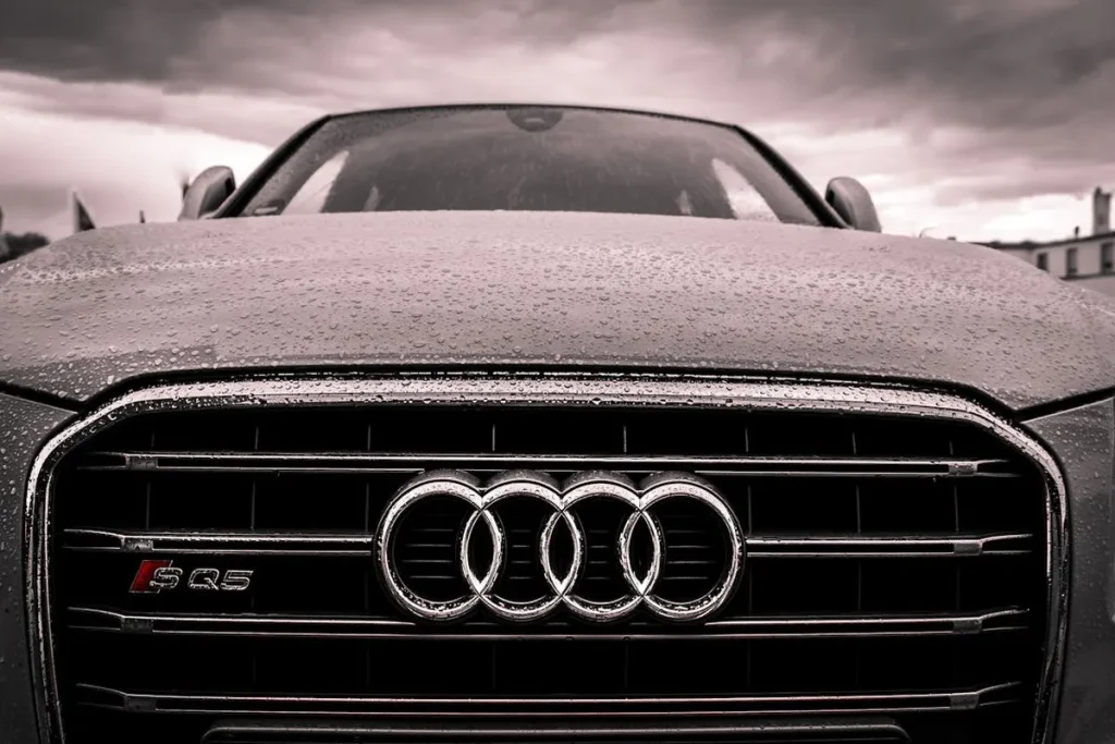 Frente de um carro Audi SQ5 com gotas de chuva, simbolizando a conquista de veículos de luxo por meio de cartas de crédito contempladas.