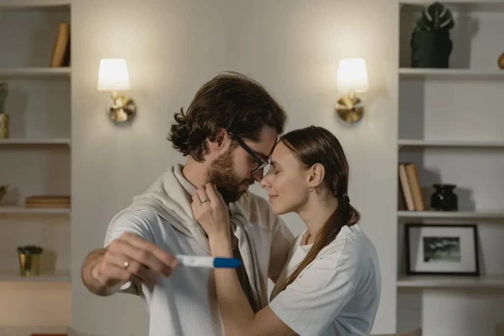 Casal emocionado e abraçado, segurando um teste de gravidez com resultado positivo, simbolizando o sucesso de uma jornada de fertilização in vitro.