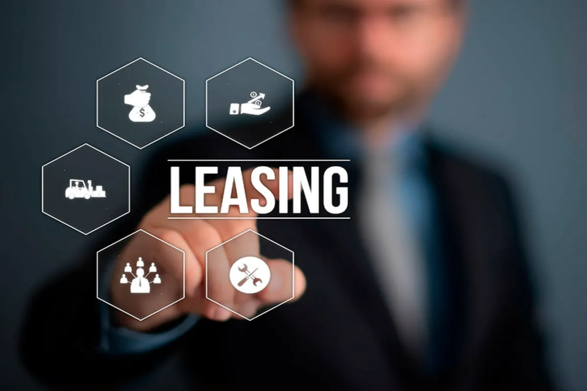 Mão de empresário tocando a tela digital com a palavra "LEASING" rodeada por ícones de dinheiro, equipamentos, recursos humanos e ferramentas, representando soluções de financiamento para empresas.
