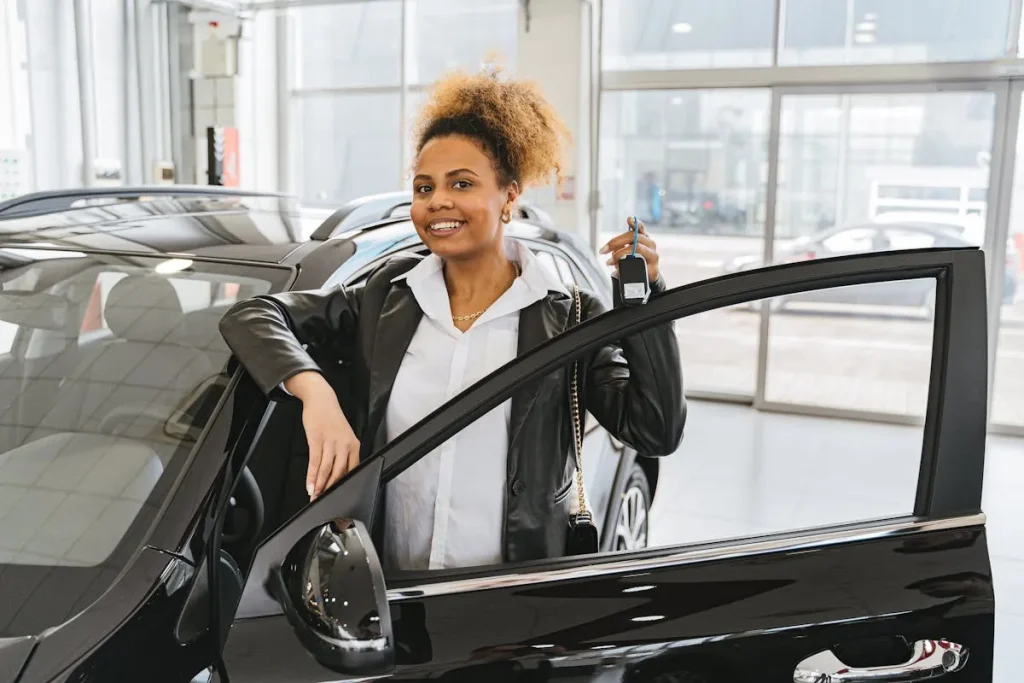 Mulher sorridente segurando chave de carro novo simbolizando conquista ao comprar carro sem entrada