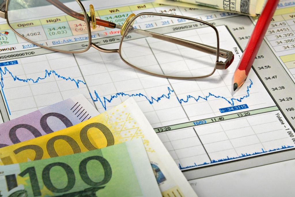 Folhas com gráficos e cédulas espalhadas